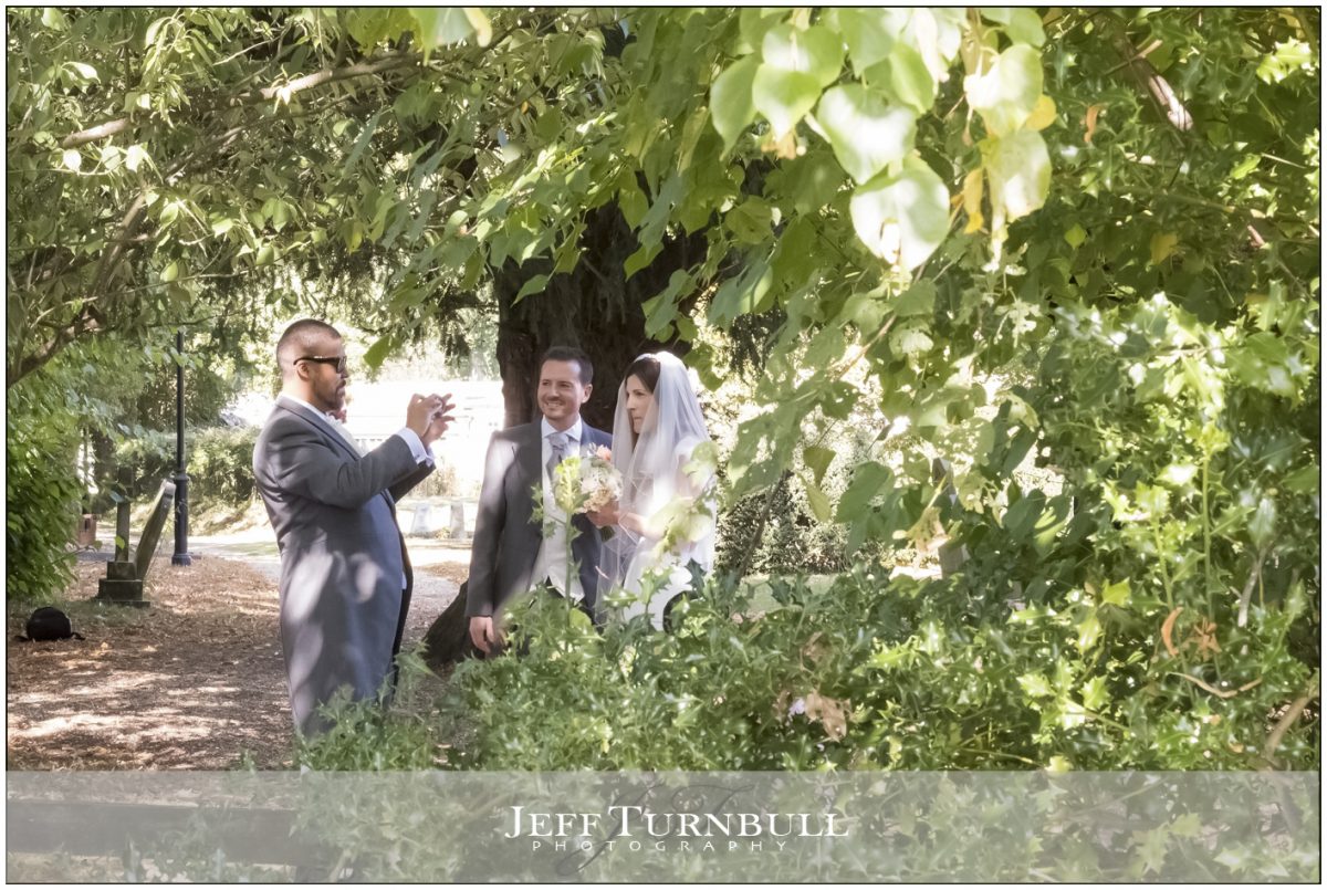 Best man taking a photograph of bride and groom