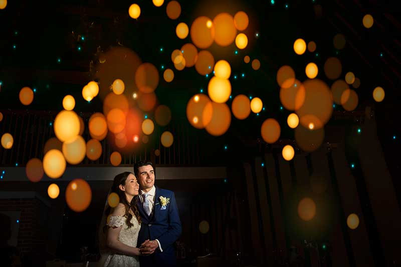 Bride and Groom Underneath Some Sparkiing Lights