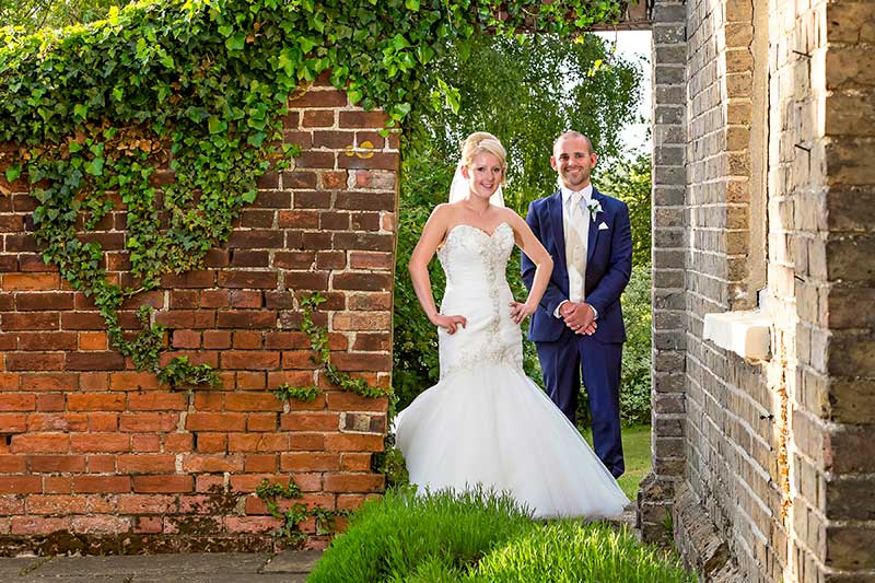 Bride and Groom Posing Under the Archway at The Reid Rooms Wedding Venue 