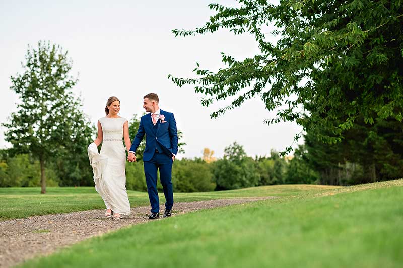 Bride and Groom Walking and Holding Hands at Little Channels Wedding Venue