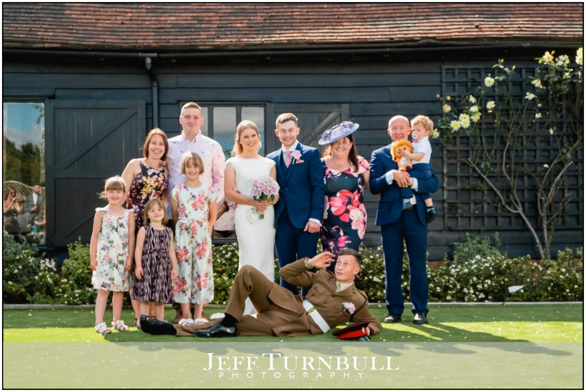 Family Photo with Bride and Groom with the Best Man Lying on the Floor