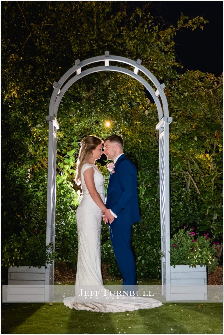 Bride and Groom under an Archway at Night Time at Little Channels