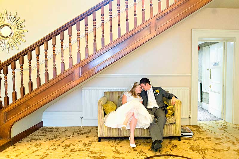 Bride and `Groom Sitting on a Sofa under the Stairs at Pontlands Park