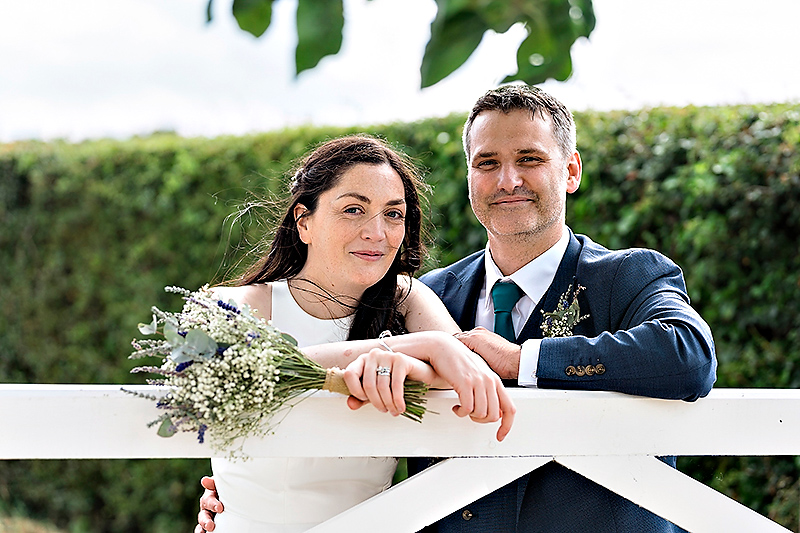 Bride-and-Groom-leaning-on-the-Gate-at-the-Compasses